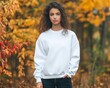 © Werckmeister - young pretty female in the outside fall background with a blank crewneck sweatshirt on.