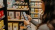 © Tati - Woman scans product in grocery store with her smartphone