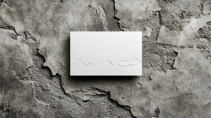 A sleek business card mockup rests on a textured concrete background