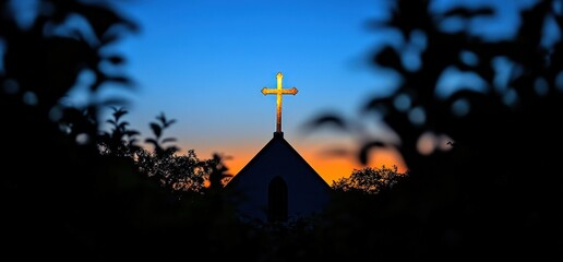 Church steeple with cross against a sunset sky framed by foliage.