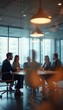 © natakot - A group of business professionals engaged in a meeting in a modern glass-walled conference room, discussing strategy and collaboration. The image highlights corporate teamwork and professional