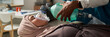 © pressmaster - Medical professional holding oxygen mask over Muslim patient face, providing emergency care. Hospital equipment and supplies visible in background