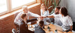© Prostock-studio - Teamwork And Unity. Business Colleagues Holding Hands During Corporate Teambuilding Meeting Sitting Together At Desk In Modern Office.