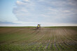© Dmytro - The tractor sprinkles the field with fertilizer