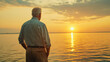 © Taras Vykhopen - Elderly man standing on the shore at sunrise, embracing the tranquility of the ocean waves