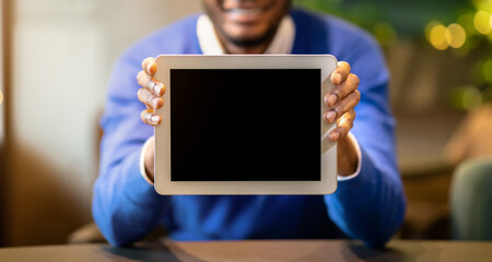 Poster - Cool App. Black young man showing tablet computer blank screen sitting at loft cafe, mock up