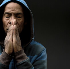 man praying to god with hands together Caribbean man praying on black background with people stock photos stock photo stock image	