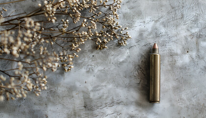 Bullets and beautiful dry plant on grey textured table, closeup