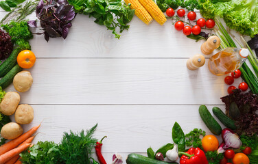 Wall Mural - Frame of fresh organic vegetables on white wood background. Healthy natural food on table with copy space. Cooking ingredients top view, mockup for recipe or menu