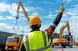© Ala - Worker directs crane operation on a busy construction site during the day
