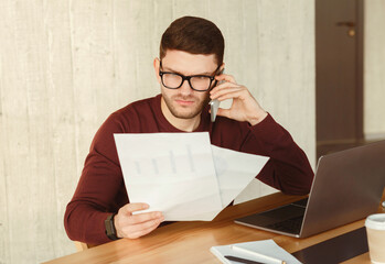 Poster - Displeased Office Manager Talking On Phone Holding Papers Sitting At Workplace Indoor. Problems At Work