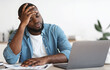 © Prostock-studio - Stressed Black Male Entrepreneur Having Problems At Work. Depressed African American Man Sitting Upset At Desk With Laptop In Office And Touching Head In Despair, Closeup Shot With Free Space