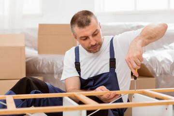 Fototapete - Professional Carpenter Fixing Wooden Shelf With Screwdriver Assembling Furniture During Renovation In Flat Indoor. Carpentry Concept