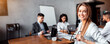 © Prostock-studio - Business Career. Businesswoman Smiling To Camera Sitting On Corporate Meeting With Coworkers In Modern Office. Copy Space