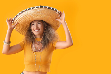 Mature woman in sombrero hat on yellow background. Mexico's Day of the Dead (El Dia de Muertos) celebration