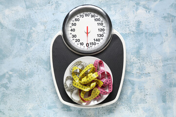 Wall Mural - Scales and measuring tapes on light blue grunge background. Weight loss concept