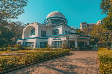 A white and blue building with a dome, surrounded by trees and greenery.