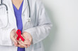 © Jo Panuwat D - Doctor with Red Ribbon for December World Aids Day, acquired immune deficiency syndrome, multiple myeloma Cancer Awareness month and National Red ribbon week. Healthcare and world cancer day concept