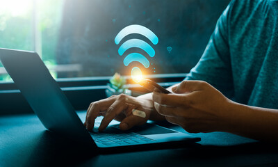 Wall Mural - hands using mobile phone and laptop with glowing wifi icon and login screen in technology concept. d