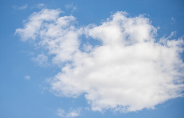 A cloudless blue sky with a large white cloud in the middle