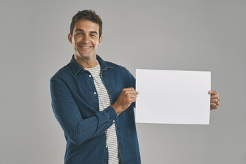 Poster - Portrait, smile and man with poster, blank and promotion with happy guy on gray studio background. Face, person and model with billboard, opportunity and design with confidence, sales or mockup space