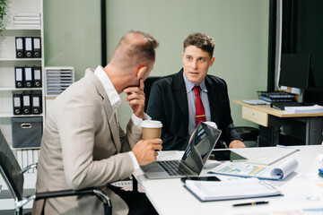 Professionals brainstorming and analyzing charts during a business meeting. Highlighting teamwork, strategy, and collaboration in a modern office environment.