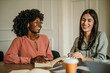 © La Famiglia - Shot of two diverse businesswomen sharing ideas during a meeting in the office