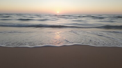 Poster - Gentle waves lap at the sandy shore at sunrise.