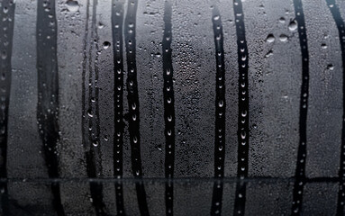 Poster - Water droplets on a window pane, creating a pattern of streaks and condensation.