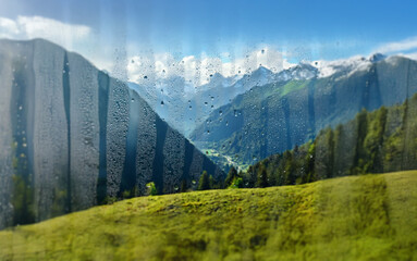 Poster - A view of snow-capped mountain peaks through a rain-streaked window.