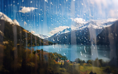 Poster - A view of a mountain range and a lake through a window covered in raindrops.