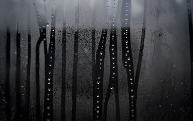 Aufkleber - Rain streaks and water droplets cling to a windowpane, blurring the view beyond.