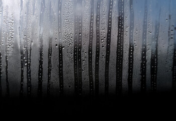 Poster - Condensation forms streaks of water droplets on a windowpane.