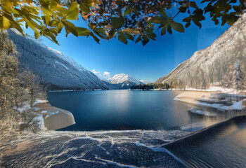 Poster - A view of a lake surrounded by snow-capped mountains.  The lake's surface is calm and reflects the blue sky.