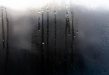Poster - Condensation forms on a window pane, blurring the view behind it.