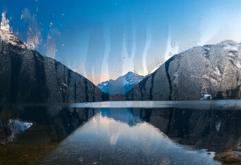 Poster - A mountain lake with a clear blue sky and snow-capped mountains in the background.  The water is still and reflects the mountains and sky.