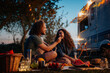© Halfpoint - Couple having romantic picnic during camping trip in nature. Man feeding his girlfriend. Caravan traveling for young people.