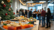 © Ruslan - Table with different food in office against background of colleagues and decorated Christmas tree at New Year corporate party