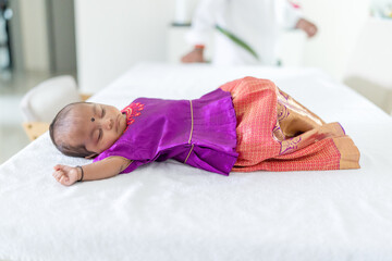 Wall Mural - An Indian family wearing traditional and casual costumes spends time with their baby, girl and grandparents in a high-rise apartment building in Kuala Lumpur, Malaysia. June 2024