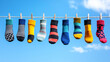© Quality One   - Brightly colored socks hanging on clothesline against clear blue sky create cheerful and playful atmosphere. vibrant patterns and colors add fun touch to scene