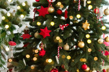 Wall Mural - christmas tree with red and gold toy balls and stars, lights bokeh in the background, merry christma