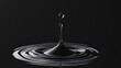 © Apaporn - A close-up shot of a single water droplet creating ripples on a dark background, capturing the essence of fluid movement and tranquility.