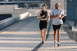 © Westend61 - Happy couple jogging at footpath on sunny day