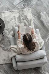 Poster - A woman sits comfortably on a chair reading a book