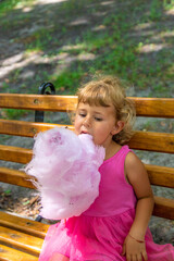 Poster - Child eating cotton candy in the park. Selective focus.