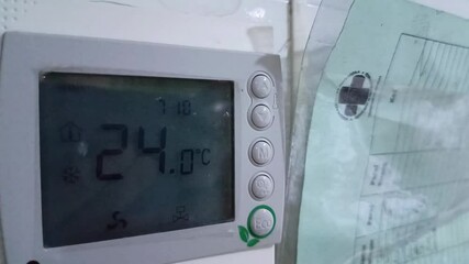 closeup up Digital thermostat Home climate control equipped with several buttons and a screen attached to the hospital wall is next to the data of all patients. for technology, interior, lifestyle