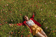 © VISTA by Westend61 - Happy woman lying on flowering plants in field