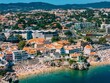 © robertharding - Aerial view of Cascais beaches and colourful rooftops of coastal town under bright sunlight with Sintra mountains in the background, Cascais, Portugal, Europe