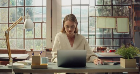 White Woman Uses a Laptop in a Sunlit Office. Successfull White  Woman Working on Computer, Doing Digital Company Marketing, Creative Writing, Coding, Research. Front View Portrait