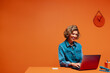 © Jacob Lund - Woman in denim shirt using laptop for e-commerce in modern office